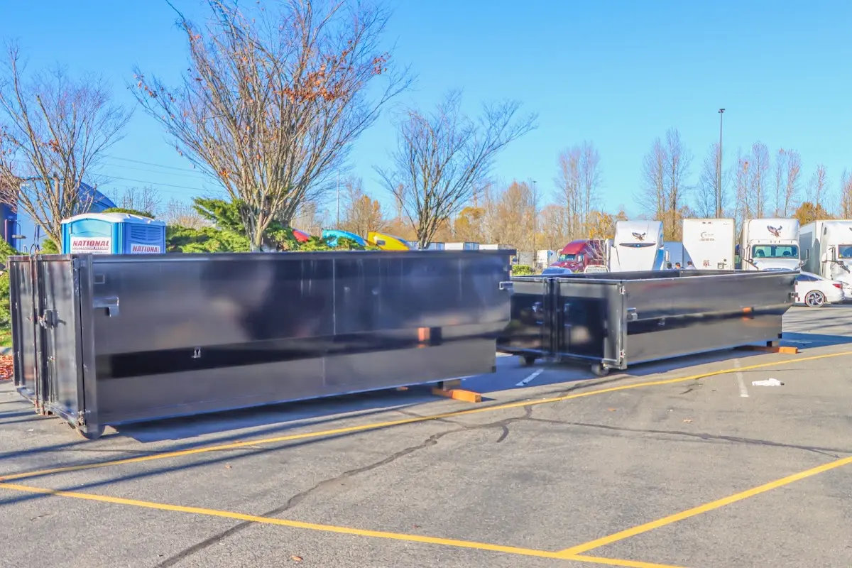 Professional dumpster rental service with roll-off container on residential driveway in Candler-McAfee